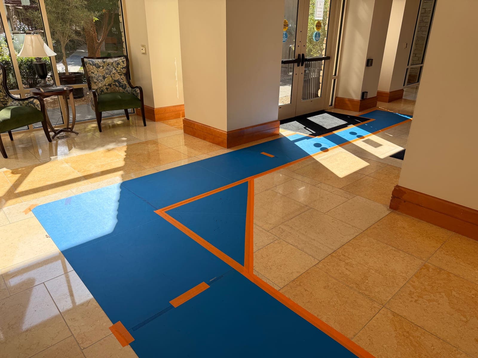 Protective floor runners taped across a polished marble lobby floor